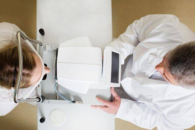 Doctor and Patient Using Phoropter for Eye Exam in Kyle, TX